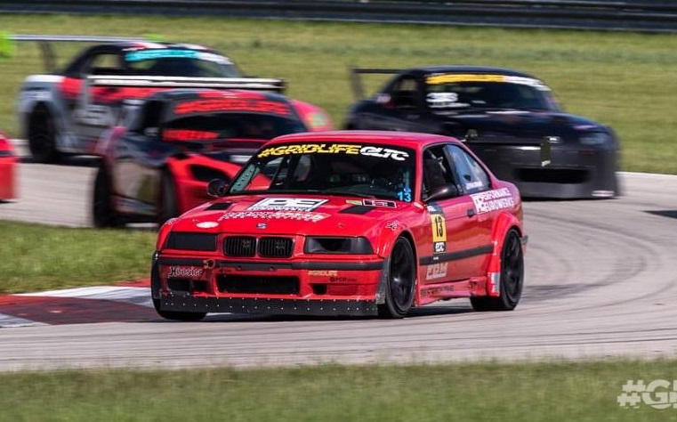 Ryan leading a field of race cars in his red BMW E36 M3
