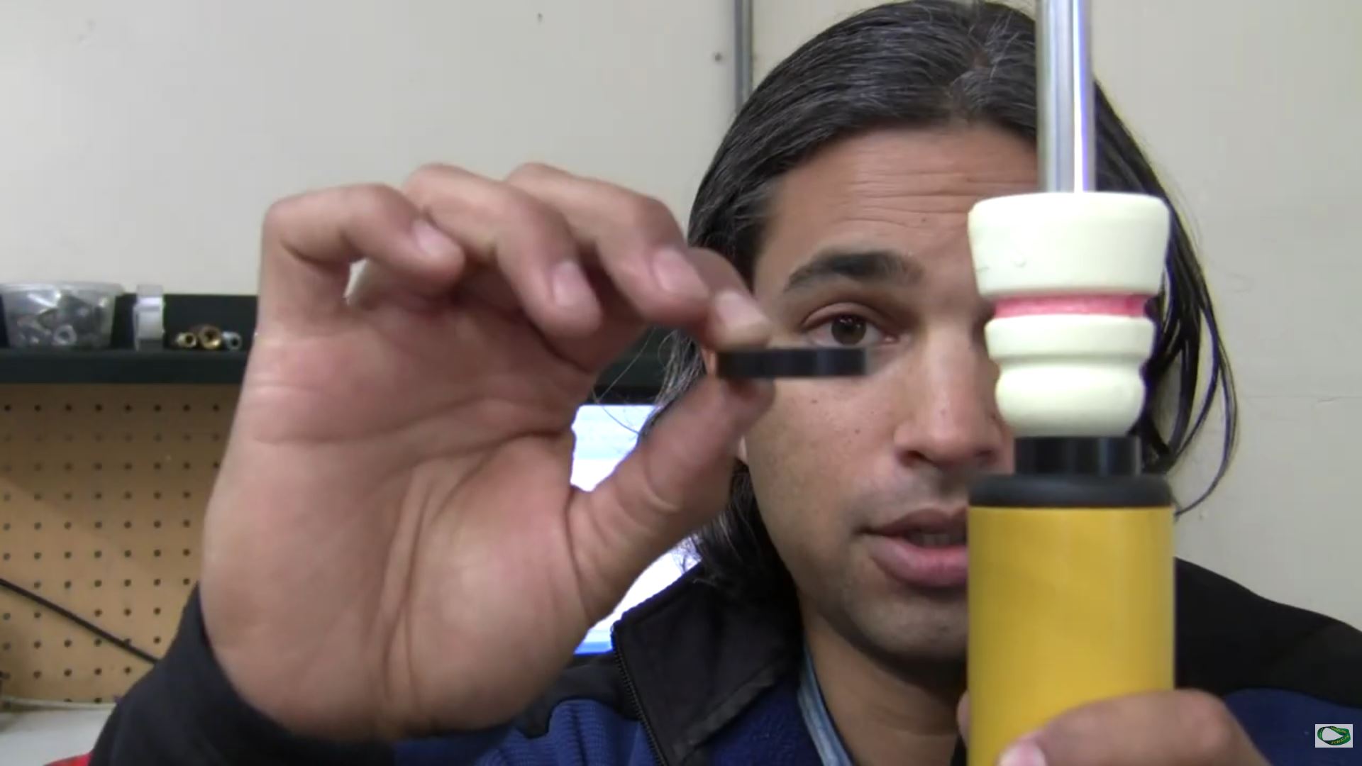 Jalal demonstrating a packer beneath a bump stop on a suspension mockup